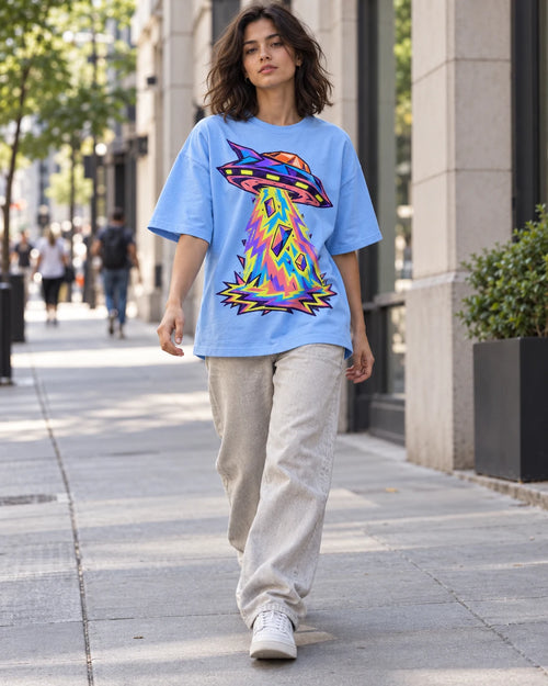 Woman walking down a city street in the Arcade Anomaly baby blue French terry oversized tee