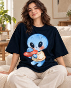 Woman on a sofa in a navy blue oversized French terry t-shirt with a blue alien in a sweater hugging a small red UFO