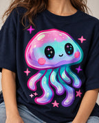 Close-up of a pastel jellyfish with starry eyes and pink sparkles printed on a navy blue oversized French terry t-shirt