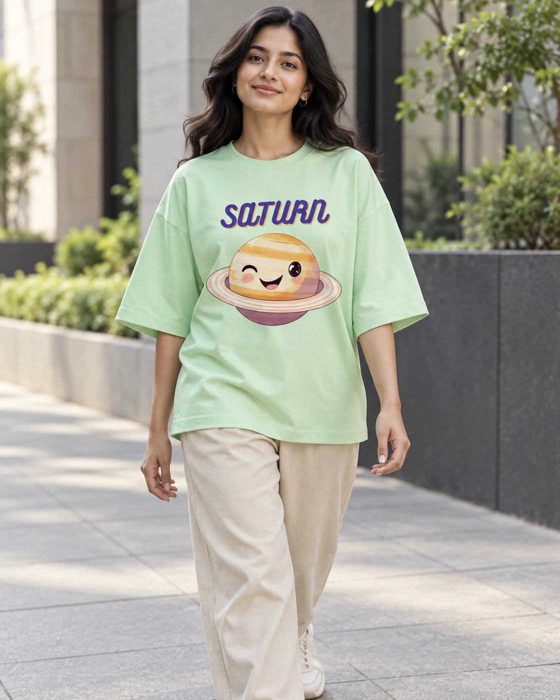Model wearing the Saturn Stellar Squad oversized French terry T-shirt in jade by Fourth Dimension Club on a city street